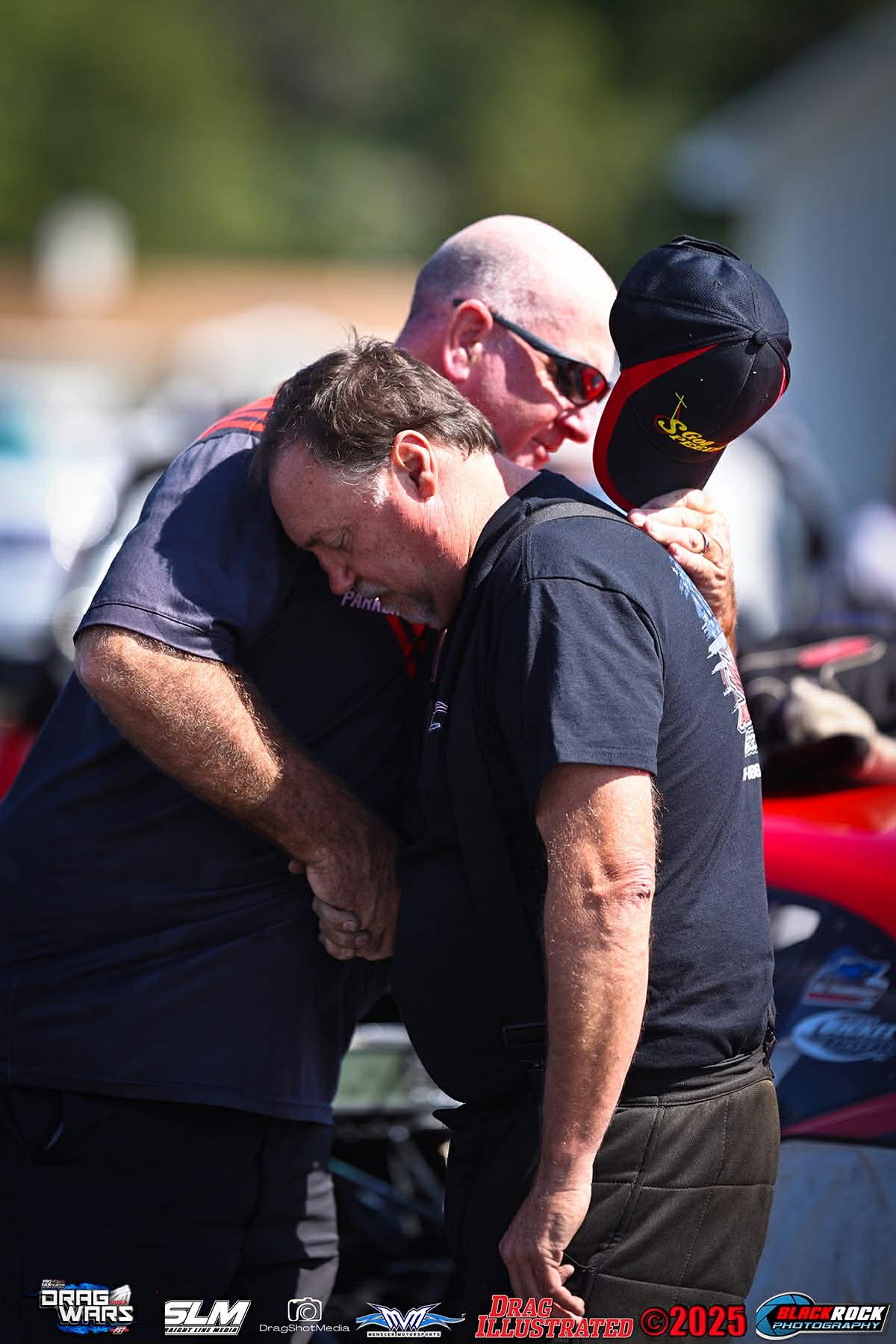 Men share a heartfelt hug outdoors