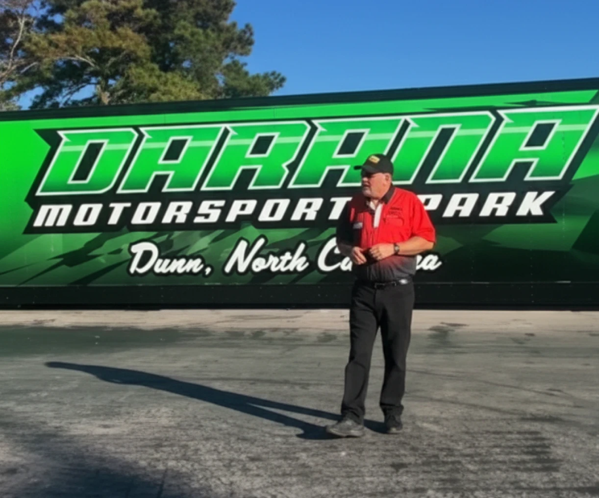 Man in front of motorsport park sign