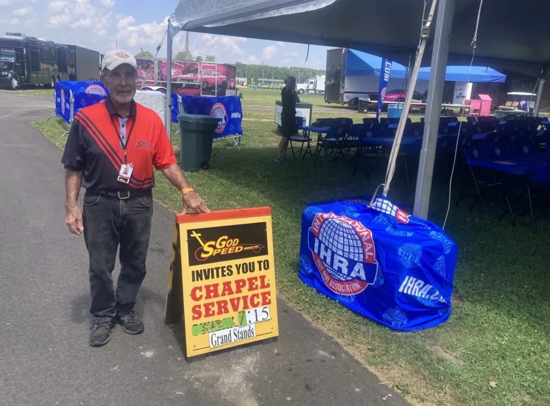 Man standing beside chapel service sign
